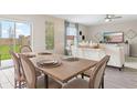 Open-concept dining area with a sliding glass door to the backyard and modern decor and a fan at 4778 Golden Knight Blvd, Kissimmee, FL 34746