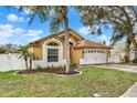 Inviting single-Gathering home showcasing a landscaped front yard and attached two-car garage, enhancing curb appeal at 390 Lisa Karen Cir, Apopka, FL 32712