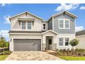 Charming two-story home featuring a gray and white exterior, covered entry, and a two-car garage at 5789 Timber Meadow Way, St Cloud, FL 34771