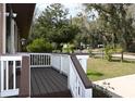 Inviting front porch with wooden deck, brown trim, and a view of the yard at 9461 Cr 657, Bushnell, FL 33513