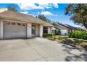 Charming home featuring a well-manicured lawn, long driveway, and mature trees at 5054 Fairfield Dr, Lakeland, FL 33811