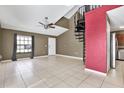 Bright living room featuring neutral tile flooring, and a unique spiral staircase at 5054 Fairfield Dr, Lakeland, FL 33811