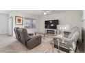 Cozy living room featuring comfortable seating, a large TV, and modern decor at 2723 Elmbrooke Way, Edgewater, FL 32141