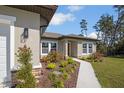 Charming front exterior with stone accents, lush landscaping, and a well manicured yard at 524 Marion Oaks Blvd, Ocala, FL 34473