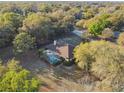Aerial view of a single-Gathering home with a pool surrounded by mature trees at 5261 Waterwood Dr, Bartow, FL 33830