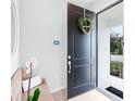 Inviting entryway with modern black front door, wreath, and a wooden bench with decorative pillows at 1324 Painted Bunting Ave, Oakland, FL 34787