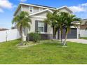 Well-maintained two-story home with a gray garage door, gray siding, and landscaped front yard at 1741 Hill Top Dr, Dundee, FL 33838