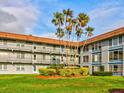 Low angle building exterior with mature landscaping and palm trees at 333 Lake Howard Dr Nw # 314D, Winter Haven, FL 33880