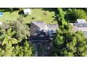 An aerial view of a charming single-story home featuring a dark roof, spacious yard, and mature trees at 111 2Nd St # Jpv, Winter Haven, FL 33880