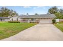 Charming single-story home with a light blue door, spacious driveway, and two-car garage at 5105 Se 25Th St, Ocala, FL 34480