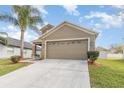 A home with a two-car garage, well-maintained lawn and landscaped garden bed at 1724 Holton Rd, Lakeland, FL 33810