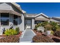 Inviting front entrance showcasing a walkway lined with manicured bushes, leading to a charming home exterior at 2009 Salinas Ave, The Villages, FL 32159