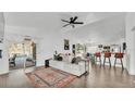 Bright living room with high ceilings, laminate flooring, ceiling fan, and sliding door to the backyard at 5152 Belmont Park Way, Mulberry, FL 33860