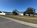 Exterior view of a light blue home showcasing the well-maintained lawn and white fencing at 89 Winter Ridge Cir, Orlando, FL 32835