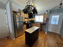 Functional kitchen with light wood cabinets, stainless steel appliances, and a pot rack at 89 Winter Ridge Cir, Orlando, FL 32835