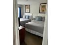 Cozy bedroom featuring two beds with stylish gray bedding and framed artwork on the walls at 6337 Parc Corniche Dr # 2101, Orlando, FL 32821