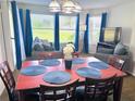 Dining area features a wood table with seating for six, and large windows with bright blue curtains at 6337 Parc Corniche Dr # 2101, Orlando, FL 32821
