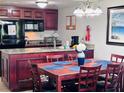 Cozy kitchen with wood cabinets, granite countertops, and essential appliances including a microwave and black refrigerator at 6337 Parc Corniche Dr # 2101, Orlando, FL 32821