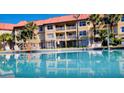 Exterior shot of a community pool with palm trees, lounge chairs, and a multi-story building backdrop at 6337 Parc Corniche Dr # 2101, Orlando, FL 32821