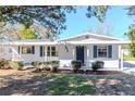 Picture of a white house with blue shutters, well maintained landscaping, and a covered entryway at 211 W Valencia St, Lakeland, FL 33805