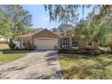 Inviting front exterior with a two-car garage, mature landscaping and walkway to entry at 7641 Sw 185Th Cir, Dunnellon, FL 34432