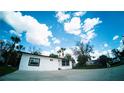 Bright white single-story home with well-manicured lawn and concrete driveway against a blue sky at 1401 Josephine St, Lakeland, FL 33815