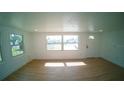 Bright living room featuring new wood flooring, white walls and ample natural light from large windows at 1401 Josephine St, Lakeland, FL 33815