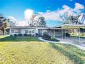 Charming single-story home with a covered carport and well-maintained lawn at 305 Bearcreek Dr, Bartow, FL 33830