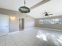 Bright living room with tile flooring, a decorative ceiling fan, and ample natural light at 305 Bearcreek Dr, Bartow, FL 33830