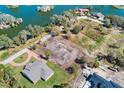 An aerial view of property showcasing the foundation, surrounding trees, and a nearby lake at 2569 Rogers Rd, Lakeland, FL 33812