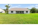The house features a large backyard with white exterior walls and a covered patio with lots of windows at 2569 Rogers Rd, Lakeland, FL 33812