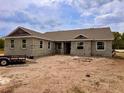 An unfinished concrete block home with a brown roof sits on a sunny lot waiting to be completed at 2569 Rogers Rd, Lakeland, FL 33812