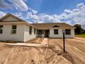 Charming single-story home showcasing light exterior and a well-manicured, spacious front yard under a blue sky at 2569 Rogers Rd, Lakeland, FL 33812