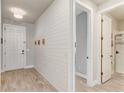 Bright entryway with wood-look tile flooring, a shiplap accent wall, and a modern light fixture at 5618 Winterbrook Way, Winter Park, FL 32792