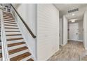 Staircase and entryway featuring wood stairs, white shiplap accent wall and wood-look tile flooring at 5618 Winterbrook Way, Winter Park, FL 32792