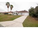 View of the house with long driveway and a well-manicured lawn at 2370 Sw 146Th Loop, Ocala, FL 34473