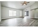 Open-concept living room featuring wood-look flooring, ceiling fan, and ample natural light from a large window at 2370 Sw 146Th Loop, Ocala, FL 34473