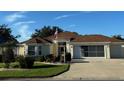 Well-maintained single-story home featuring an American flag, bay window, and a two-car garage at 348 Ellenton Run, The Villages, FL 32162