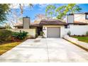 Charming townhouse featuring a gray garage door, well-kept landscaping, and private drive at 3808 Ne 17Th St # 3808, Ocala, FL 34470