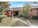 Charming brick home featuring a covered front porch and lush landscaping at 5670 Sw 34Th St, Ocala, FL 34474