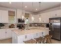 Bright kitchen with stainless steel appliances, large island, pendant lighting, and white cabinets at 16198 Honey Harvest St, Winter Garden, FL 34787