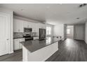 Modern kitchen featuring white cabinets, stainless steel appliances, a gray countertop, and wood-look flooring at 348 Lake Smart Cir, Winter Haven, FL 33881