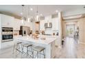 Bright and airy kitchen showcasing white cabinets, stainless steel appliances, pendant lighting and a large center island at 5260 Stone Ridge Pl, St Cloud, FL 34771