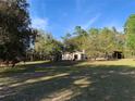 Exterior view of charming home surrounded by lush greenery and mature trees at 24605 Ne 177Th Ter, Fort Mc Coy, FL 32134