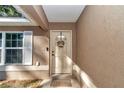 Inviting front entrance with a decorative wreath on the door and a welcoming 'HOME' door mat at 4111 Se 131St Ln, Belleview, FL 34420