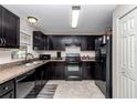 This kitchen features dark cabinetry, tile floors, and essential appliances for convenient meal preparation at 4111 Se 131St Ln, Belleview, FL 34420