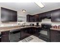 An updated kitchen featuring sleek, dark cabinets, neutral countertops, and modern appliances at 4111 Se 131St Ln, Belleview, FL 34420