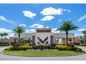 Community monument with a modern design surrounded by well-maintained landscaping and palm trees at 7540 Brooklyn Dr, Kissimmee, FL 34747