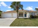 Charming single-story home featuring a lush front yard, a three car garage, and a welcoming blue front door at 113 Grand Reserve Ct, Davenport, FL 33837