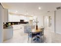 Bright, open kitchen with white cabinets, an island, and a dining area with wood table at 3217 Armstrong Ave, Clermont, FL 34714